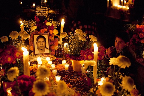 Boy by his mother's grave during the celebration of D√É¬≠a de los Muertos, the Day of the Dead at the San Pedro Cucuchucho cemetery. People decorate the graves of their loved ones with offerings of flowers, particularly marigolds (cempoalx√É¬≥c