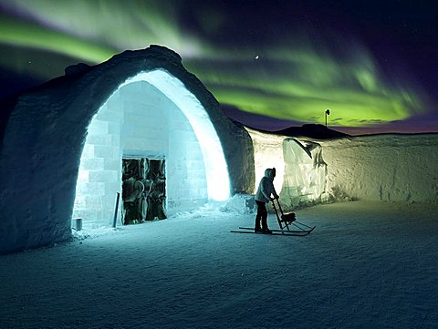 Woman on kick sled with Aurora Borealis, Ice Hotel, Jukkasjarvi, Kiruna, Lapland, Sweden, Scandinavia, Europe