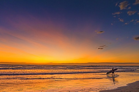 Sunset and surfer at Playa Guiones beach, Nosara, Nicoya Peninsula, Guanacaste Province, Costa Rica, Central America