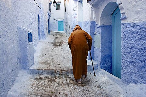 Old man walking in a typical street in Chefchaouen, Rif mountains region, Morocco, North Africa, Africa