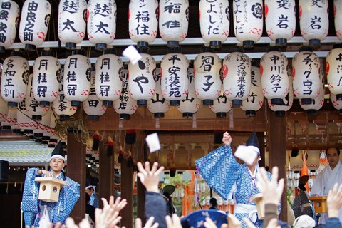 Temple monks and workers throwing beans to people during the Setsubun rituals at Yasaka Shrine
