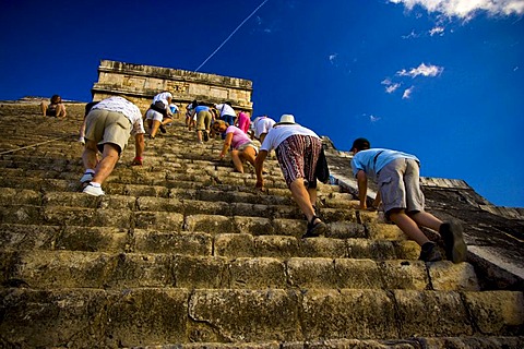 Visitors climb the steep steps of a ruin in Chichen Itza, Mexico.