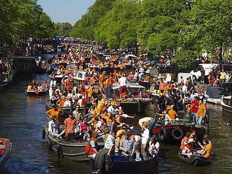 Queens Day being celebrated on a canal in Amsterdam, Amsterdam, Holland, The Netherlands