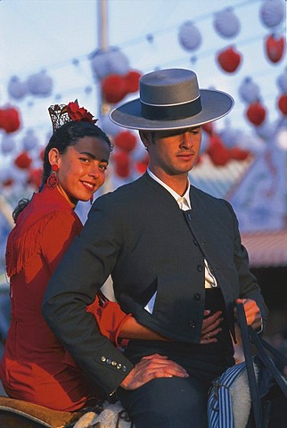Couple in traditional costumes on a horse, Feria de Abril, Sevilla, Andalusia, Spain, Europe