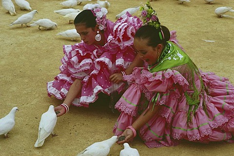 Girls feeding doves, Feria de Abril, Sevilla, Andalusia, Spain
