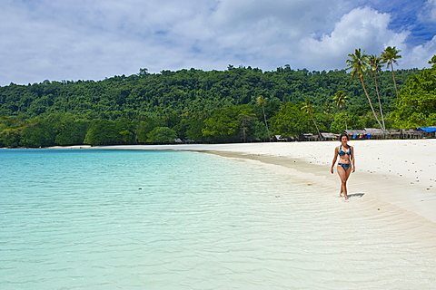 Tourist wandering along the turquoise water and white sand at the Champagne beach, Island Espiritu Santo, Vanuatu, South Pacific, Pacific