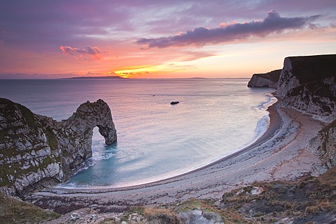 A colourful sunset over Durdle Door on the Jurassic Coast, UNESCO World Heritage Site, Dorset, England, United Kingdom, Europe