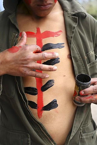 Man paints chest in the Fiestas of Inti Raymi in northern Ecuador.