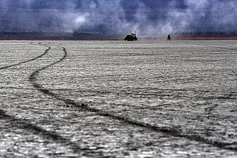 A person rides their bike along the border of Burning Man in the Black Rock Desert, Nevada on August 29, 2002.  Burning Man is an art festival that celebrates free expression.  In 2002 about 29,000 people attended the festival that started in 1986 when Lar