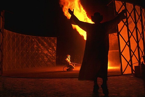 A man creates a fire tornado as another man raises his hands at Burning Man in the Black Rock Desert, Nevada on August 30, 2002.  Burning Man is an art festival that celebrates free expression.  In 2002 about 29,000 people attended the festival that starte