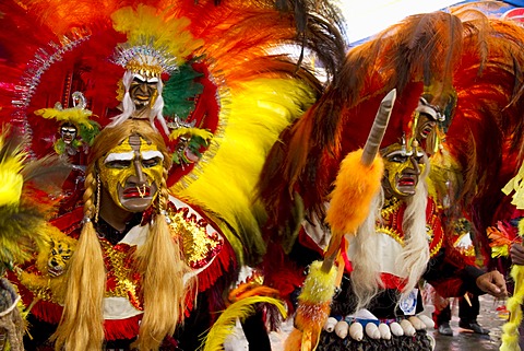 Tobas dancers wearing elaborate masks, feather headdresses and costumes in the procession of the Carnaval de Oruro, Oruro, Bolivia