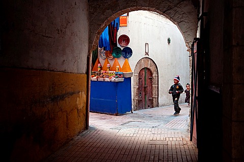 Children running through the streets of Essaouira medina, Morocco.