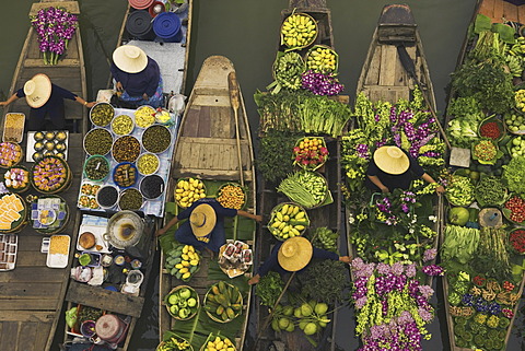 Aerial view of a floating market on a canal in Bangkok, local boats laden with fresh food, moored close together