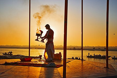 INDIA Uttar Pradesh Varanasi Performing the Ganga Aarti Ceremony at dawn over the River Ganges. India Varanasi Uttar Pradesh Aarti Ceremony River Ganges Faith Hindu Hinduism Tradition Dawn Perform Holy Sacred Sunrise Travel Tourism Holidays Asia Sub-Contin