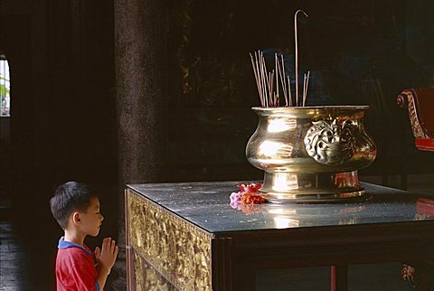 Boy praying at Kek Lok Si Temple, Penang, Kuala Lumpur, Malaysia, Asia
