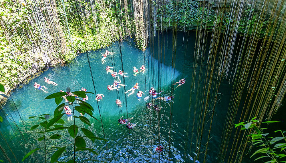People swimming in limestone sinkhole pool, Cenote Ik kil, Pisté, Yucatan, Mexico