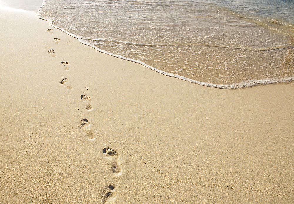 Footprints on empty sandy beach