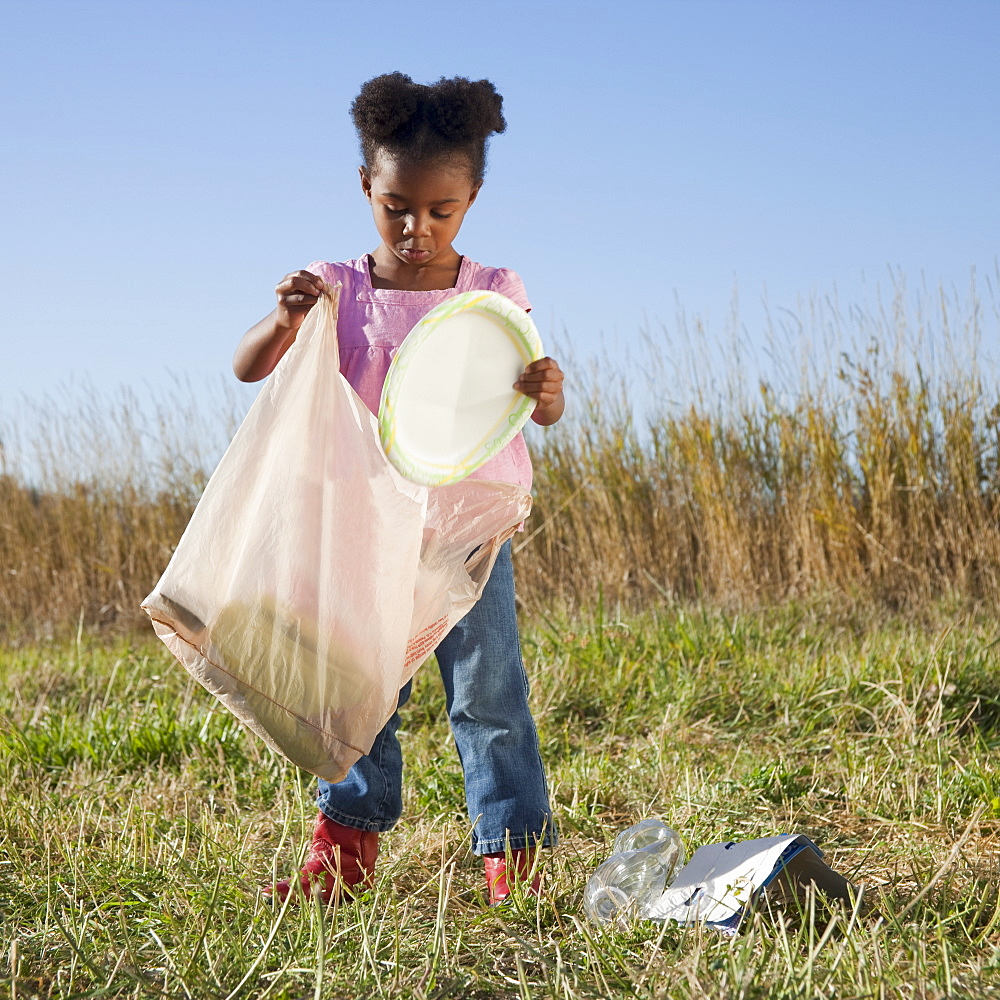 Young girl picking up litter